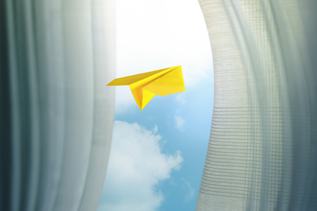 Travel, Freedom and Imagination Concept. Paper Airplanes Flying Through Window and Curtain, Selective Focus. Blue Sky as Outside Viewの写真素材