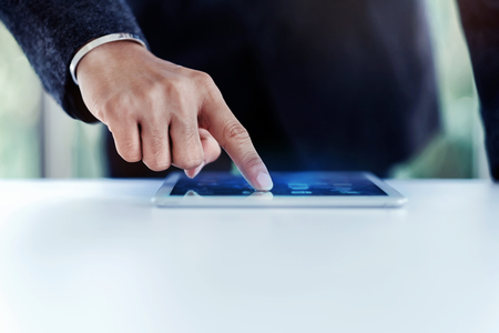 Businessman Working on Digital Tablet in Office at the Desk. Selective Focus and Cropped imageの写真素材