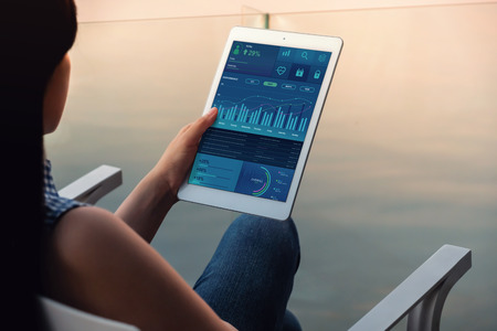 Technology in Finance and Business Marketing Concept. Graphs and Charts show on Touch Pad's Screen....