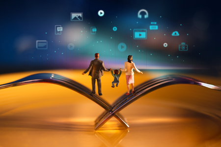 Parent,Kids and New Technology Growing together Concept. Happy Modern Family. Miniature of Father, Mother and Son Balancing body on the Fork. Blurred Media icons as backgroundの写真素材