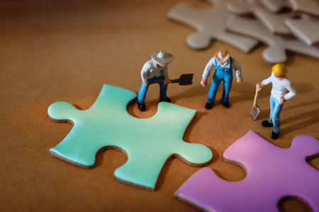 Teamwork, Business Strategy, Connection, Partnership and Team Collaborate Concept.  Group of Miniature Worker Working on Jigsaw Puzzleの写真素材