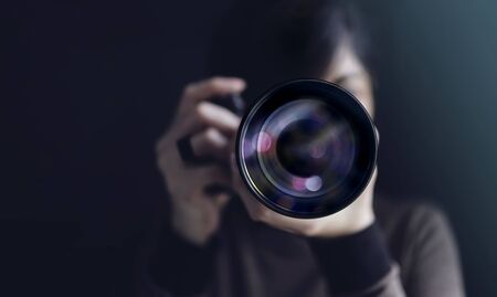 Photographer Taking Self-Portrait. Woman using Camera to Taking Photo. Dark Tone, Front View....