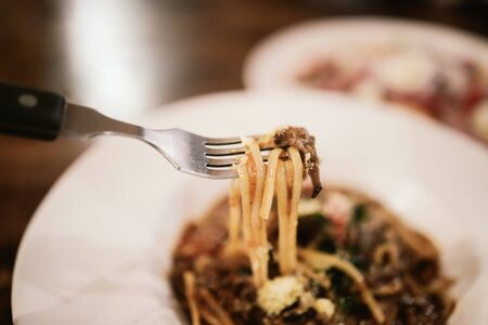 Eating Spaghetti Beef Sauce in Restaurant at Night.Selective Focusの写真素材