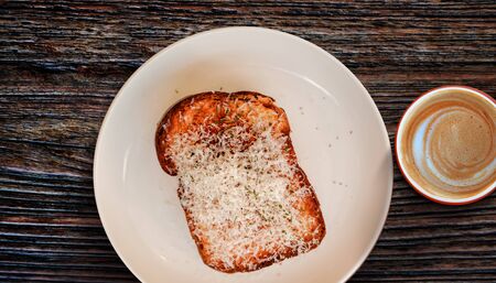 Toast Bread with Cheese on White Plate with Hot Coffee Latte. Morning Meal on Cozy Weekend.Top Viewの写真素材