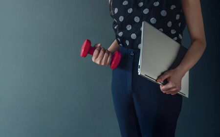 Work Life Balance Concept, present by Business Working Woman holding a Laptop and Dumbbell, Lifestyle of Modern People. Croped image with Copy Spaceの写真素材