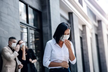 Covid-19 or Corona Virus Situation in Business Concept. Business People with Medical Mask Concern about  Virus Spread in Office. Woman Coughing in Publicの写真素材