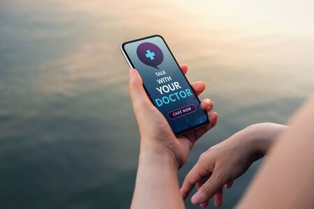 Helathy Lifestyle and Technology Concept. Modern Person Using Online Medicine Application via Mobile Phone to Request a Consultation from the Doctor about their Healthの写真素材