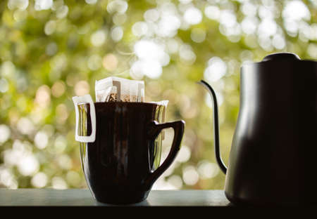 Dripping Coffee in the Backyard at Home in the Morning. Making Hot Drink by Instant Coffee Drip Bag. Zen and Cozy Livingの写真素材