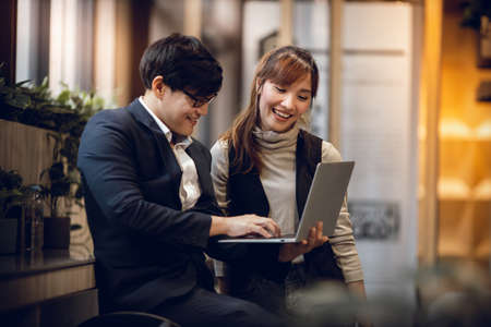 Working Together Concept. Smiling Two Business People of Man and Woman Workigng on Computer Laptop...