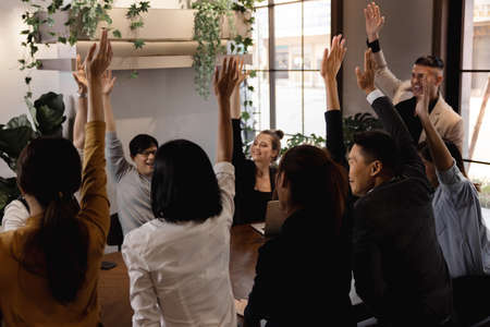 Cheerful Multiethnic Motivated Teamwork. Young Happiness Business People Voting by Raising Hands at...