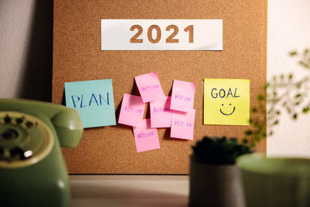Goal, Plan, Challenge and Strategy for 2021 Year Concept. Sticky Note on Cork Board on Working Desk. Closeup and Selective Focus on Goal Textの写真素材