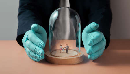 Safety and Health Insurance during Coronavirus Concept. Miniature Figure of Family walking inside a...