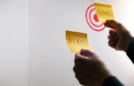 Goal, Plan, Challenge and Strategy Concept. Person making Business Plan on Sticky Note. Closeup and Selective Focusの写真素材