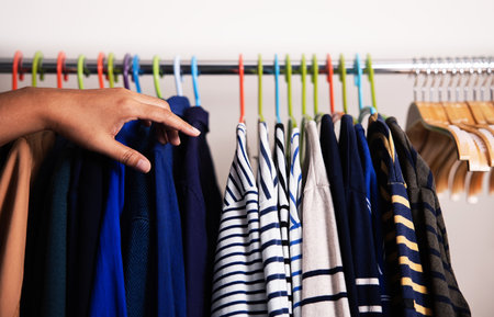 Wardrobe Rack. Men Clothes hanging on Bar by the White Wall. Fashion Lifestyle of a Stylish Man. Guy choosing for a Shirtの写真素材