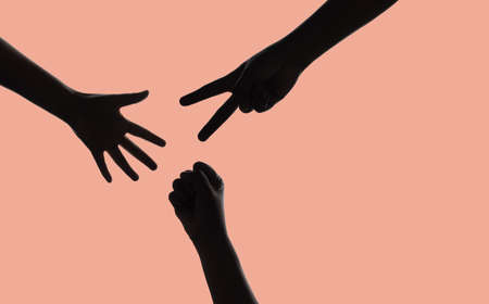 Silhouette of Hands Gesture for Rock Paper Scissor Game,  isolated on pink backgroundの写真素材
