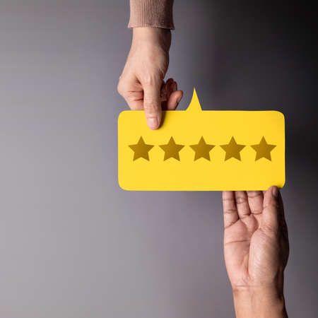 Customer Experience Concept, Happy Client giving Five Star Rating Feedback on Card to a Businessman. Top Viewの写真素材