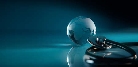 World Health Day. Global Health Care Concept. Transparent Glass Globe and Stethoscope lay on Blue background. Modern and Digital Technology Color Tone. Wide and Long sizeの写真素材