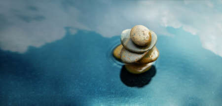 Harmony, Calm, Mind, Life Relaxing and Living by Nature Concept. Natural Stone Stack Setting on Water. Balancing Body, Mind, Soul and Spirit. Mental Health Practice. Cloudy Sky as Reflectionの写真素材