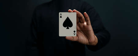 Ace Spade Playing Card. Player or Magician Holding a Poker Card. Front View. Closeup and Dark Toneの写真素材