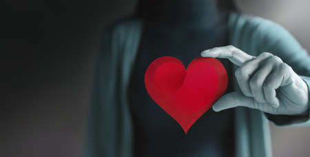 Love, Health Care, Donation and Charity Concept. Close up of Voluteer Holding a Heart Shape Paperの写真素材