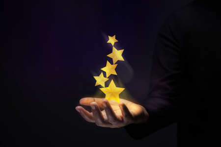 Success in Business or Personal Talent Concept. Gesture Hand with Golden Five Star Awardsの写真素材
