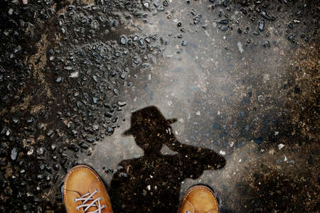 Photogrpaher taking Self Portrait by Reflection Shadow on the Ground after stopped Raining. Top Viewの写真素材