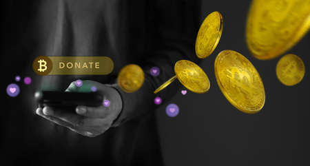 Online Donation by Cryptocurrency Concept. Closeup of Hand Using a Mobile Phone to making Donate Bitcoin via the Internetの写真素材
