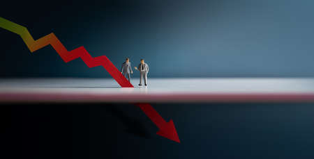 Recession, Inflation and Depression Concepts. Economic Crisis. Graph Fall Down, Business Collapse. Two Miniature Figure of Businessman Looking at a Red Graph Arrow Downの写真素材