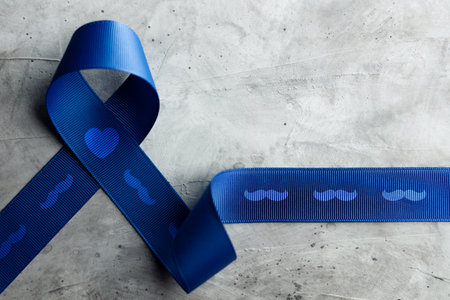 Prostate Cancer Awareness Campaign Concept. Men Healthcare. Close up of a Blue Moustache Ribbon  Lying on Rough Grey Cement Concrete background, Top Viewの写真素材