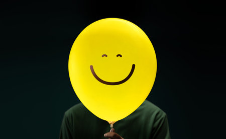 Happiness Day Concept. Happy and Optimistic Mind, Well Mental Health. Enjoying Life Everyday. Happiness Person with a Smiling Emoticon Balloonの写真素材