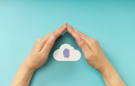 Hands shielding Fingerprint on Cloud symbol, representing Cybersecurity, data privacy, and online protection. Top Viewの写真素材