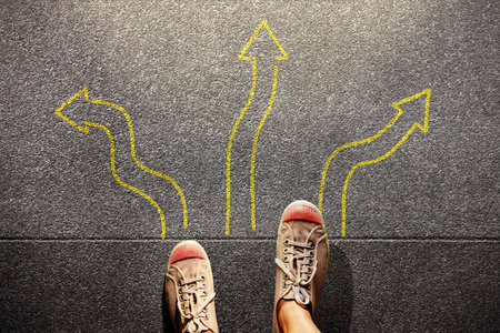 Feet standing among many drawn arrows, symbolizing decision, choice, direction, and the courage to...