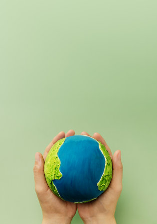 Earth in hands symbolizing sustainability, global environmental care, ecological responsibility, Vertical image, Top Viewの写真素材
