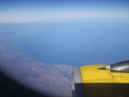 Aerial view of the wing of an airplane flying above the cloudsの写真素材