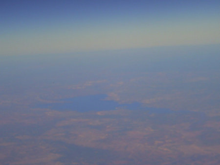Blue sky and clouds as seen through window of an aircraft during flightの写真素材