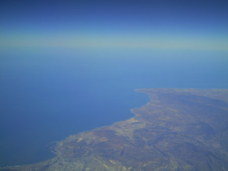Aerial view of the sea and mountains from the airplane window.の写真素材