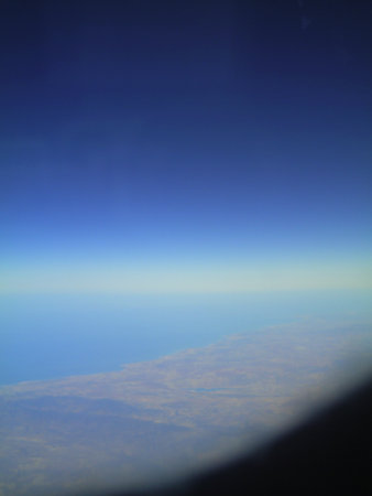 Blue sky and clouds as seen through window of an aircraft, closeup of photoの写真素材