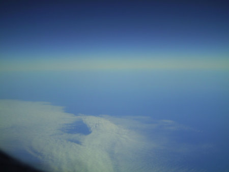 clouds in the blue sky as seen through window of an aircraftの写真素材