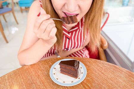 Woman eating chocolate cakeの写真素材
