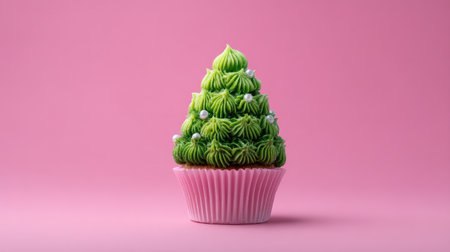 This charming green tree cupcake features intricate cream frosting on a soft pink background, perfect for festive events and celebrations.の素材