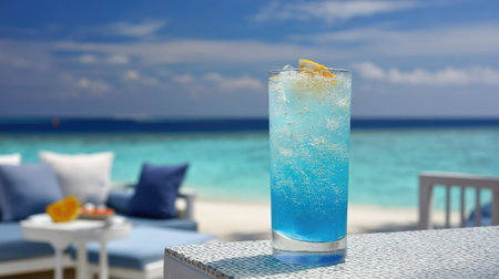 A vibrant blue drink topped with a lemon slice served in a glass, ideal for a refreshing moment at the beach. The serene ocean view enhances summer vibes.の素材