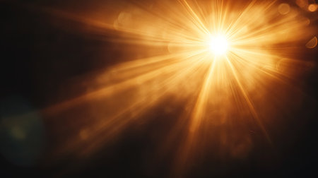 A stunning golden light burst radiates with soft rays, creating an enchanting atmosphere in darkness. Perfect for artistic or inspirational projects.の素材