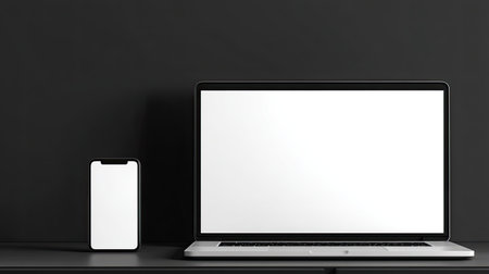A minimalistic workspace featuring a laptop and smartphone against a black background. Perfect for showcasing modern technology and design concepts.の素材