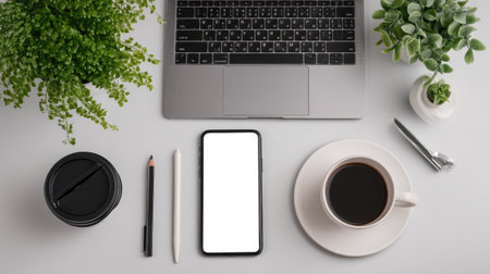 A minimalistic workspace featuring a laptop, coffee cup, smartphone, and plants. Ideal for themes of productivity and modern lifestyle in a serene environment.の素材