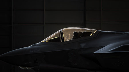 A captivating silhouette of a fighter jet cockpit set in a hangar, showcasing advanced instruments and ambient lighting, perfect for aviation enthusiasts and military themes.の素材