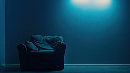 A cozy armchair placed in a dimly lit room, softly illuminated by a blue glow. The setting evokes tranquility and comfort, perfect for relaxation and introspection.の素材