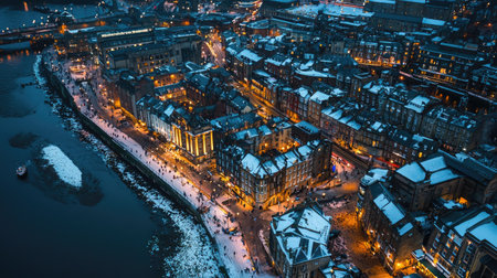A captivating aerial view of a snowy cityscape at night, showcasing illuminated buildings along the riverbank, perfect for winter-themed projects and travel inspiration.の素材