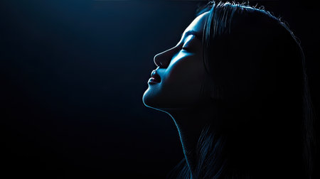 A striking silhouette profile of a woman illuminated by soft light against a dark background, evoking serenity and calmness, perfect for artistic projects.の素材