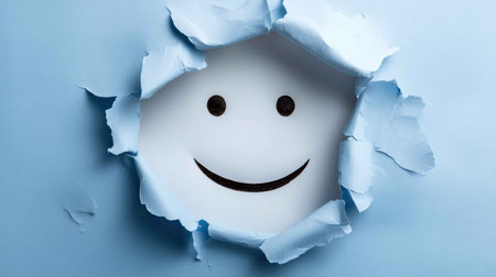 A joyful smile emerges from a torn paper backdrop, highlighted against a soft blue hue. This composition evokes feelings of happiness and creativity, perfect for uplifting designs.の素材