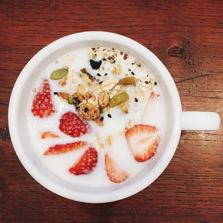 A cup of milk with trawberry and cereals.の素材